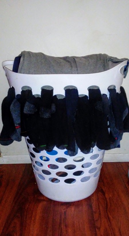 Air Dry Socks Using Laundry Basket Holes - socks hanging out of the holes