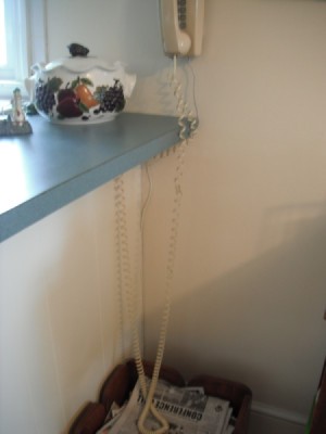 A very long telephone cord, attached to a wall phone.