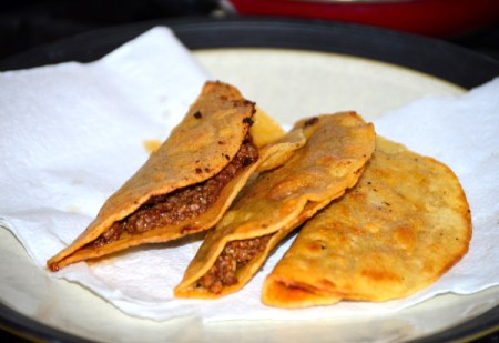 meat in folded tortillas on paper towel