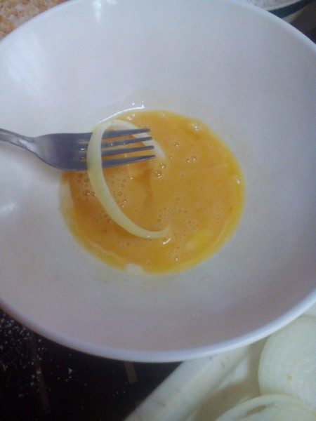 dipping onion piece in bowl