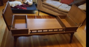 Value of a Mersman Coffee Table - medium wood finish table with covered end compartments and railing between