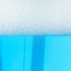Closeup of blue foamy soap in a bottle.