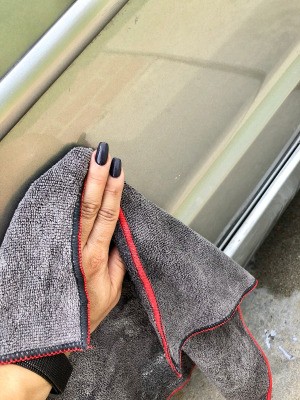 Tips for Waxing Cars - woman's hand holding a microfiber cloth
