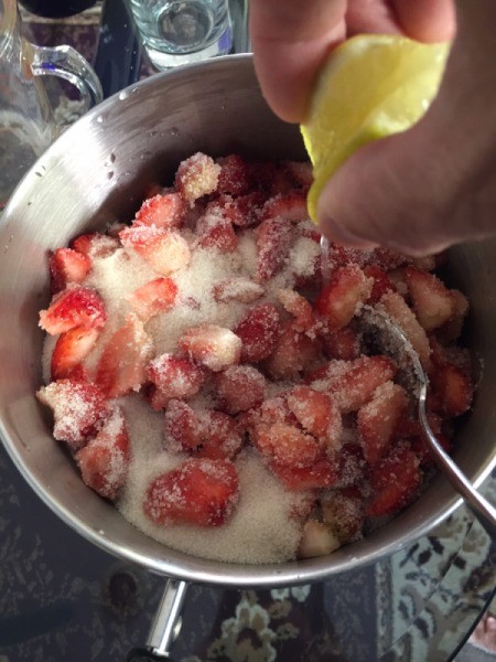 adding lemon and sugar to strawberries