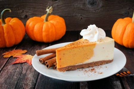 Pumpkin cheesecake with cinnamon and small sugar pumpkins on the side