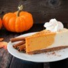 Pumpkin cheesecake with cinnamon and small sugar pumpkins on the side