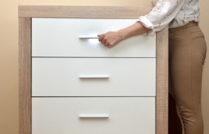 Woman trying to open a drawer.