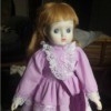 Identifying a Porcelain Doll - red haired doll wearing a purplish pink dress