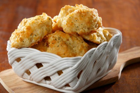 Garlic cheese biscuits in a white ceramic basket.