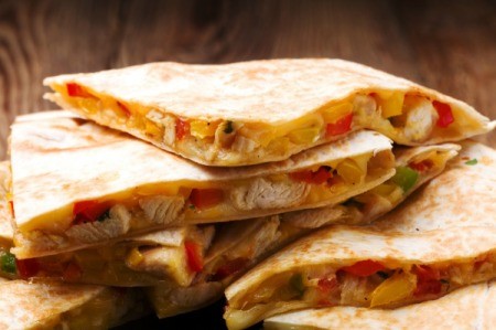 Pan Fried Chicken Quesadilla slices stacked on a plate