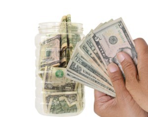 Hands holding cash to be put away for savings