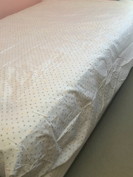 A bedsheet that is slightly too large for the bed.