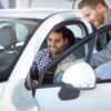 Man looking at rental car with sales person