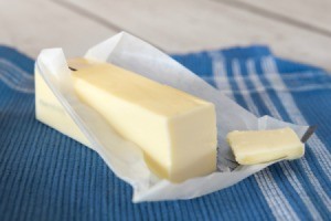 Stick of butter on a table with pat sliced off
