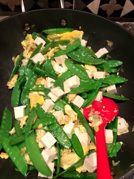 pea pods added to egg and tofu in pan