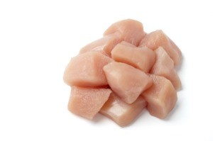 Cubed raw chicken on a white background