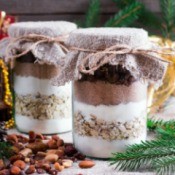 Jars filled with brownie mix in layers topped with burlap.