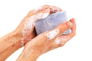 Soapy hands holding a bar of soap.
