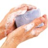 Soapy hands holding a bar of soap.