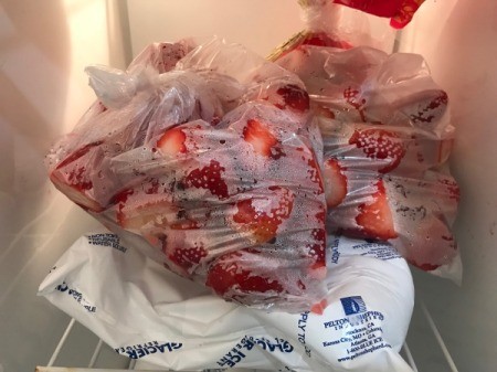 Bags of strawberries in the freezer.