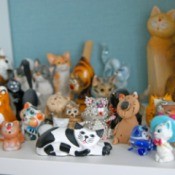 Wooden and porcelain figurines of cats from different cities and countries.