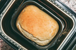 Inside of a bread machine with a loaf of fresh bread.