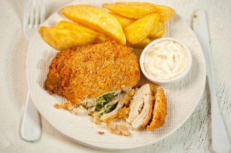 Chicken Kiev on a plate with fries.
