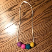 Toddler Felt Ball Necklace - finished necklace on a table top