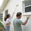 Father and daughter painting the exterior of their house.