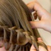 Woman braiding a girls hair
