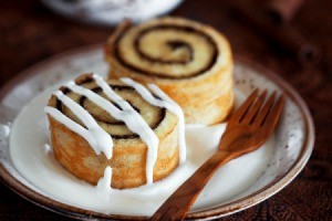 Two small cinnamon rolls on a tea saucer.