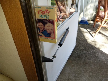 A VHS tape being used to prop a door open.