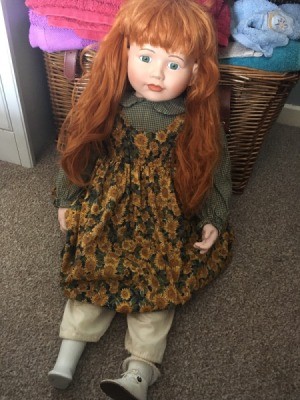Age and Maker of a Porcelain Doll - red haired doll wearing a pinofore