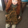 Age and Maker of a Porcelain Doll - red haired doll wearing a pinofore