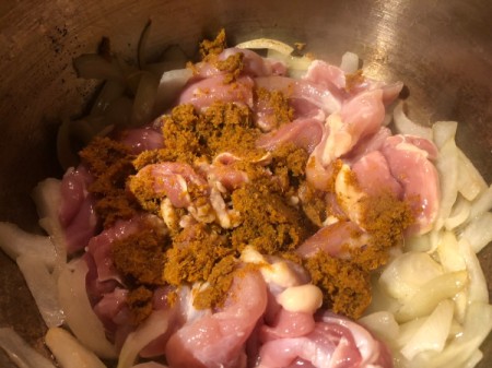 adding chicken and curry paste  to onions
