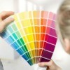 Woman selecting paint color from a color swatch catalog.