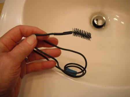 A drain snake with a brush on the end.