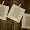 Paper picture frames with clothes pins on wood background.