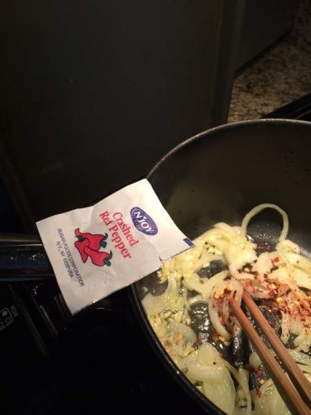 onions and garlic in skillet with crushed red pepper packet