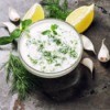 Dill dip in a bowl with lemon and garlic.