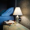 Bedside table with book lamp and glasses