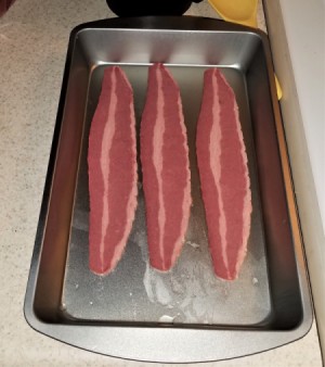 Slices of turkey bacon in a baking pan.