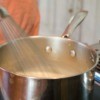 A saucepan with the contents being whisked and thickened.