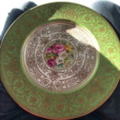 Value of Tiffany Plates by Cauldon - ornate gold filagree plate with green top edge and floral center