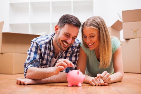 Couple putting money in piggy bank