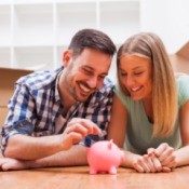 Couple putting money in piggy bank