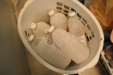 A basket full of frozen juice containers filled with water.