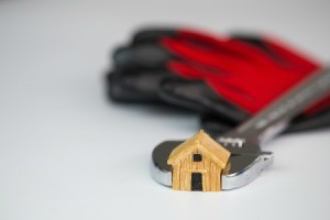 Wrench around a small wooden house.