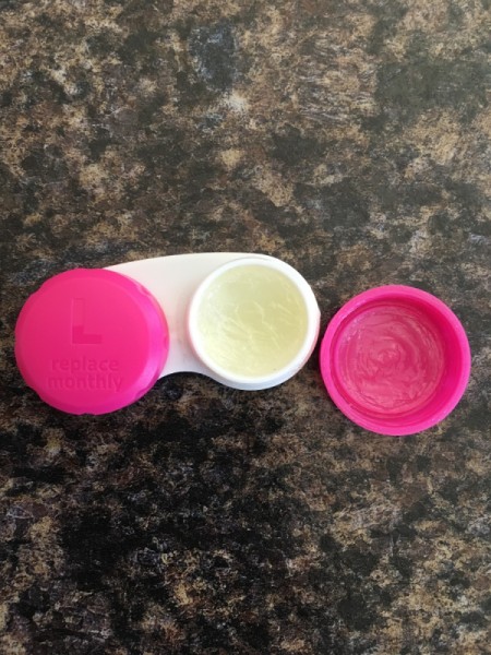 A contact lens case filled with Vaseline for use as a lip balm.