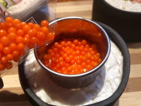 How to Make Sushi Cakes - place a round cutter in the center of one cake and fill with round orange ball candies